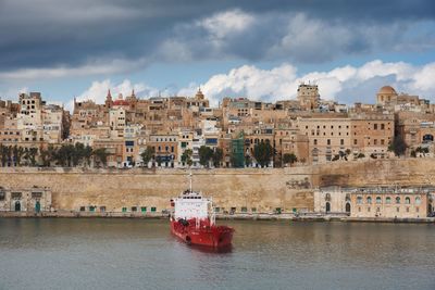 Nautical vessel on river against sky in city