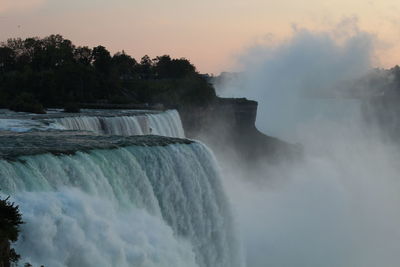 Scenic view of waterfall against sky