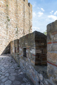 Stone wall of old building against sky