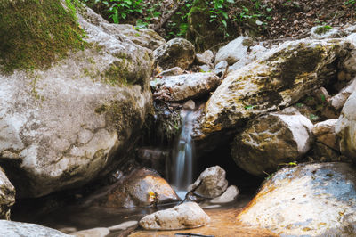 View of stream flowing through rocks