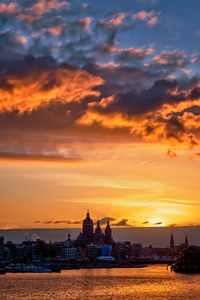 Scenic view of building against cloudy sky during sunset