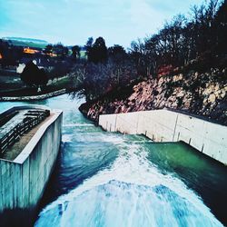 Swimming pool by river against sky