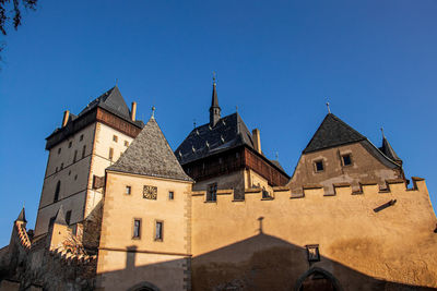 Low angle view of old building against clear blue sky