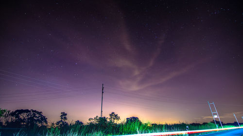 Low angle view of illuminated lights against sky at night