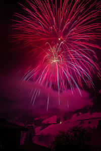 Low angle view of firework display at night