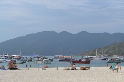 Boats moored at beach against sky