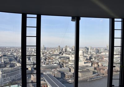 Cityscape against sky seen through glass window