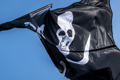 Low angle view of flag against clear blue sky