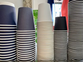 Multicolor stacking paper cups on coffee machine.