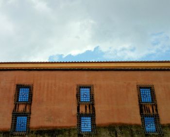 Low angle view of building against cloudy sky