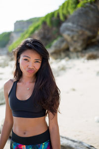 Portrait of beautiful young woman standing at beach