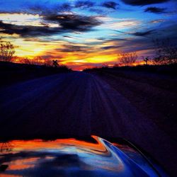 Car on road against sky during sunset