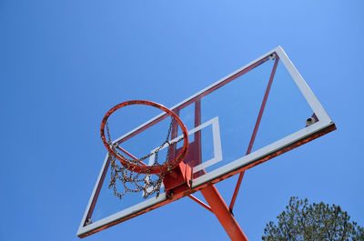 Basketball chain hoop and tree with blue sky as background