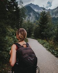 Rear view of woman standing by road