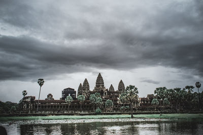 Temple by lake against sky