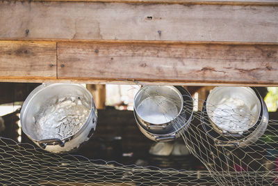 Close-up of cooking utensils hanging from wood