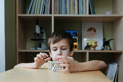 The child plays table football on the desk. speech therapy game for the development of breathing