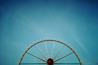 Low angle view of ferris wheel against blue sky