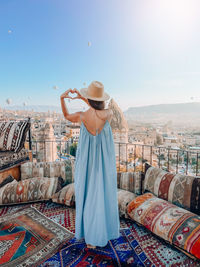 Rear view of woman wearing hat while standing against sky