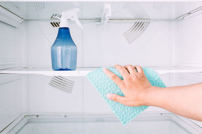 Cropped hands of woman cleaning fridge at home