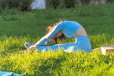 Side view of woman on grass in field