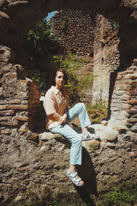 Portrait of smiling young woman standing on rock