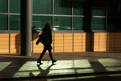 Side view of silhouette woman standing in city