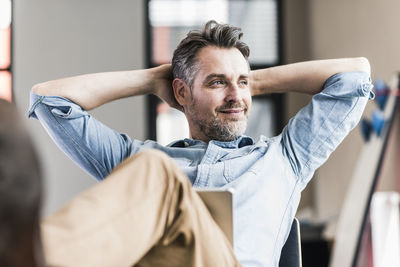 Businessman in office leaning back