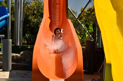 Happy woman enjoying on slide at water park