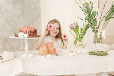 Portrait of cute girl showing flowers at home