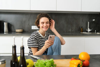 Portrait of young woman holding food at home