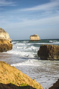 Scenic view of rocks on beach against sky