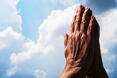 Low angle view of hand against sky