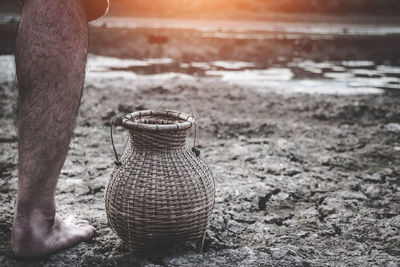 Low section of man with wicker basket on field