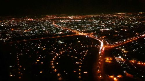 Aerial view of illuminated cityscape against sky at night