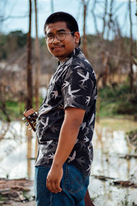 Side view of young man looking away outdoors