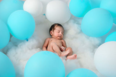 Full length of shirtless boy with balloons