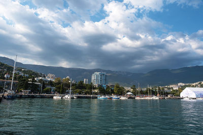 Scenic view of sea by buildings against sky