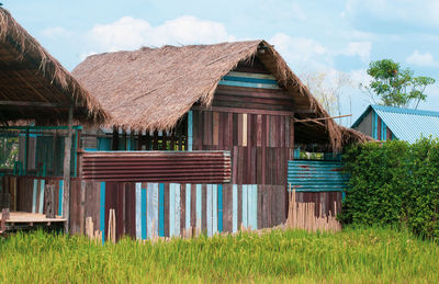 Panoramic view of house and trees on field against sky