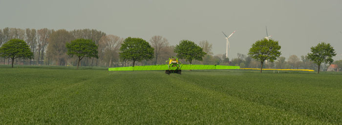 Tractor with field sprayer when applying pesticide against pesticide