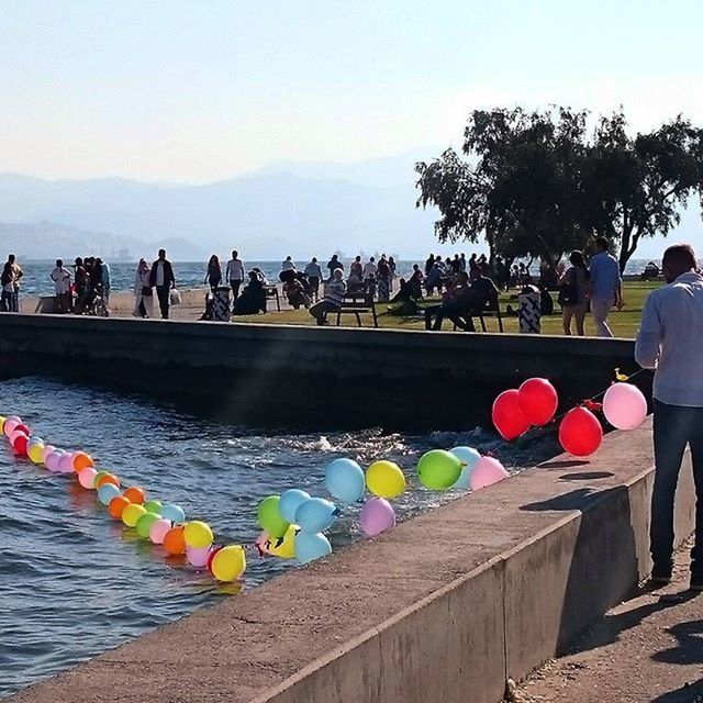 sky, in a row, water, tree, railing, nature, day, clear sky, outdoors, incidental people, lifestyles, person, tranquil scene, leisure activity, men, beauty in nature, fence, multi colored, tranquility