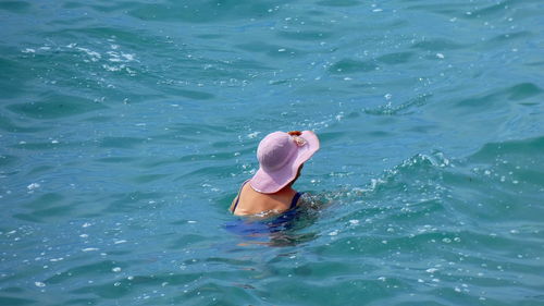 Rear view of shirtless man in swimming pool