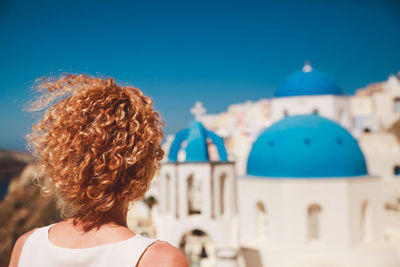 Rear view of woman against church on sunny day