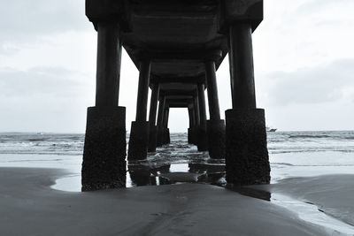 View of pier on beach against sky