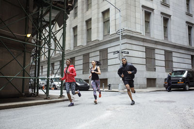 Determined athletes jogging on city street