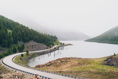 Scenic view of lake by mountains against sky