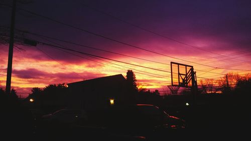 Silhouette of road against cloudy sky at sunset