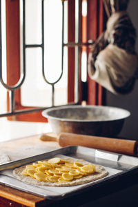 Close-up of food in tray on table against window at home