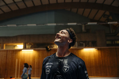 Happy male athlete with wet face at sports court