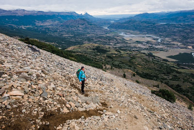 Woman standing on landscape against sky